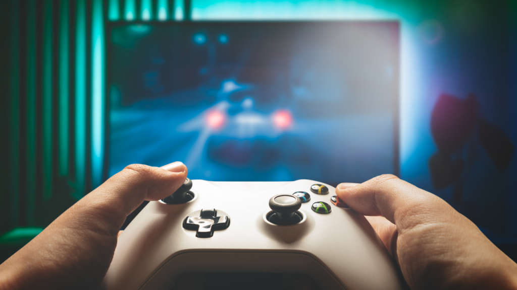Hands gripping a game controller, racing game on screen—captures my passion for gaming and the thrill of competition.